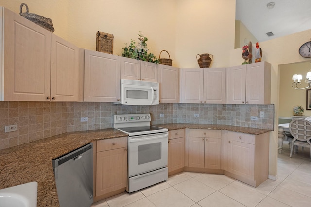 kitchen featuring decorative backsplash, light tile patterned floors, white appliances, and light brown cabinetry