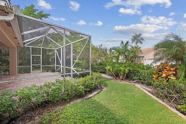 view of yard featuring glass enclosure and a patio area