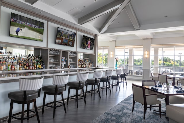 bar with beamed ceiling and dark wood-type flooring