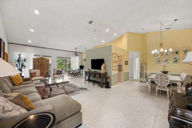 living room with ceiling fan with notable chandelier, light tile patterned floors, and vaulted ceiling