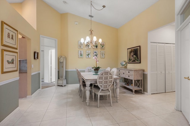 dining space featuring light tile patterned floors, high vaulted ceiling, and an inviting chandelier