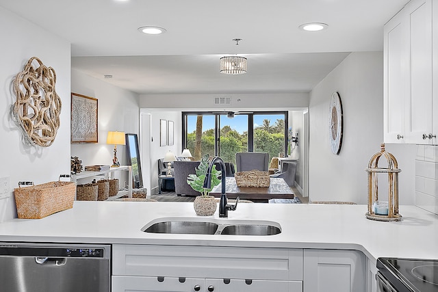 kitchen with appliances with stainless steel finishes, white cabinetry, and sink