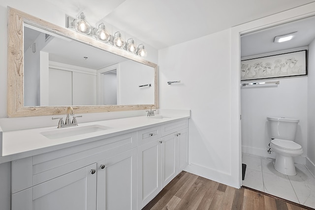 bathroom featuring toilet, hardwood / wood-style flooring, and vanity