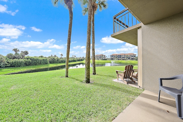 view of yard with a water view and a patio