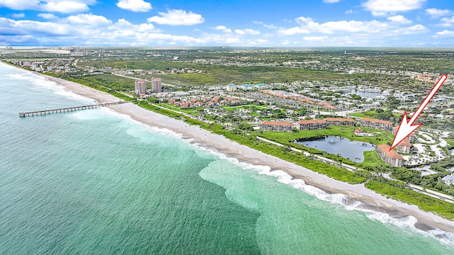 drone / aerial view featuring a water view and a view of the beach