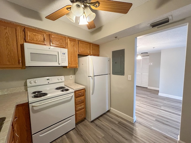 kitchen featuring electric panel, ceiling fan, a textured ceiling, light hardwood / wood-style floors, and white appliances