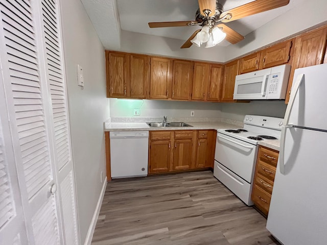 kitchen featuring white appliances, light hardwood / wood-style floors, sink, and ceiling fan