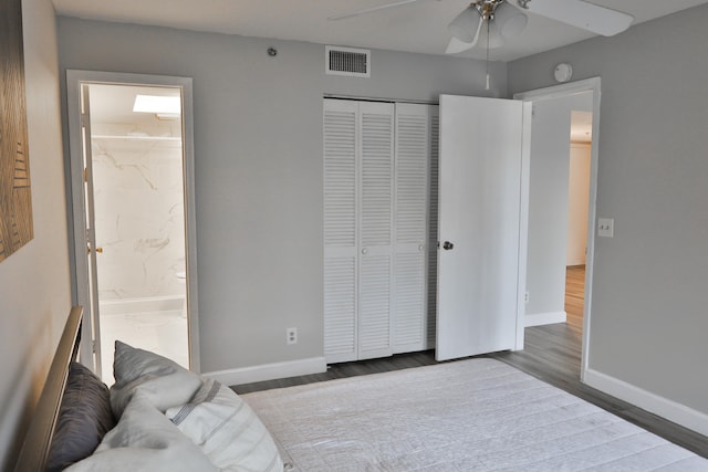 bedroom featuring a closet, ensuite bath, hardwood / wood-style flooring, and ceiling fan