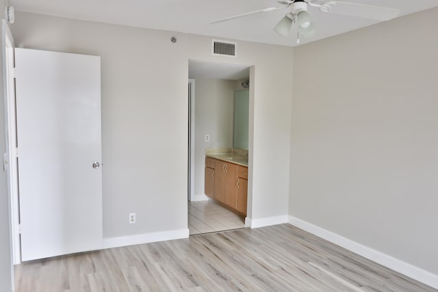 unfurnished bedroom featuring connected bathroom, ceiling fan, and light wood-type flooring