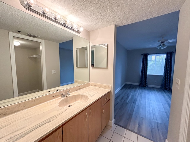 bathroom with vanity, hardwood / wood-style floors, a textured ceiling, and ceiling fan