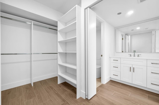 walk in closet featuring sink and light wood-type flooring