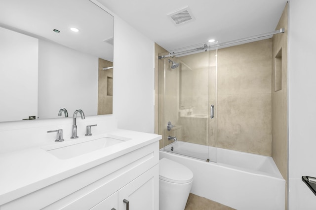 full bathroom featuring vanity, bath / shower combo with glass door, and toilet