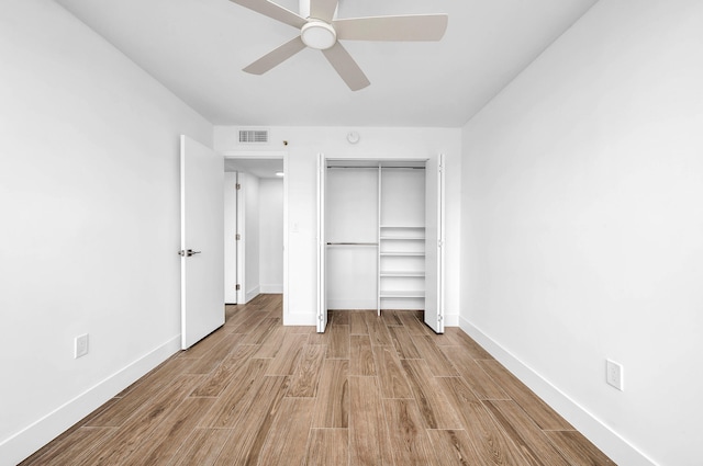 unfurnished bedroom with a closet, light wood-type flooring, and ceiling fan