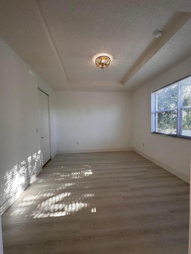 spare room with a textured ceiling and hardwood / wood-style flooring