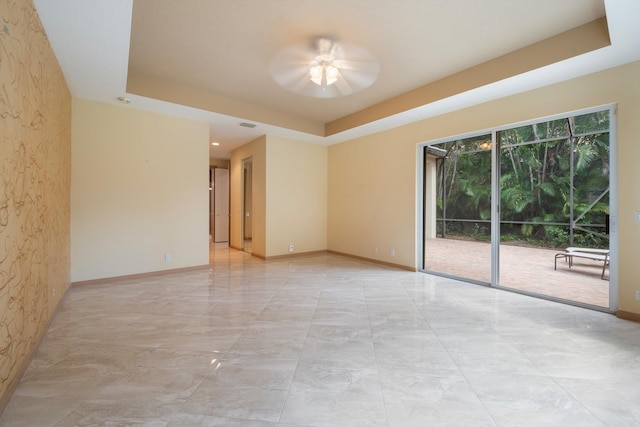 unfurnished room featuring a tray ceiling and ceiling fan