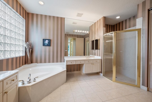 bathroom featuring separate shower and tub, tile patterned floors, vanity, and a textured ceiling