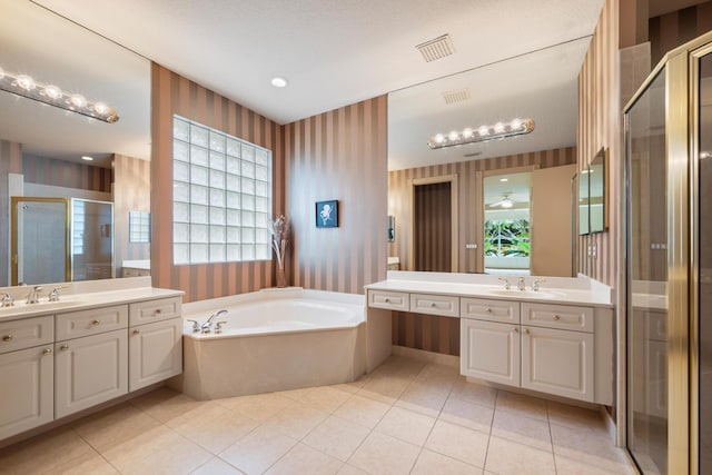 bathroom featuring plus walk in shower, vanity, and tile patterned flooring