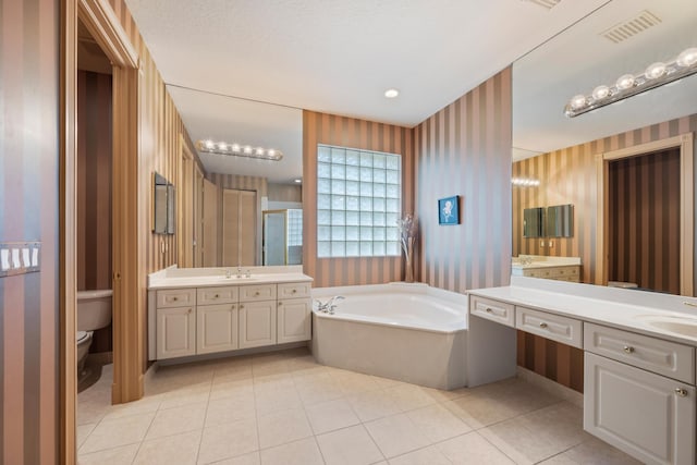 bathroom featuring a tub to relax in, tile patterned flooring, vanity, and toilet