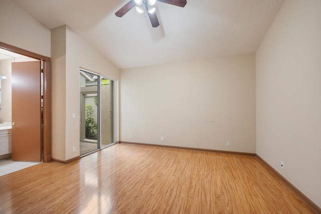 empty room featuring a textured ceiling, light wood-type flooring, vaulted ceiling, and ceiling fan