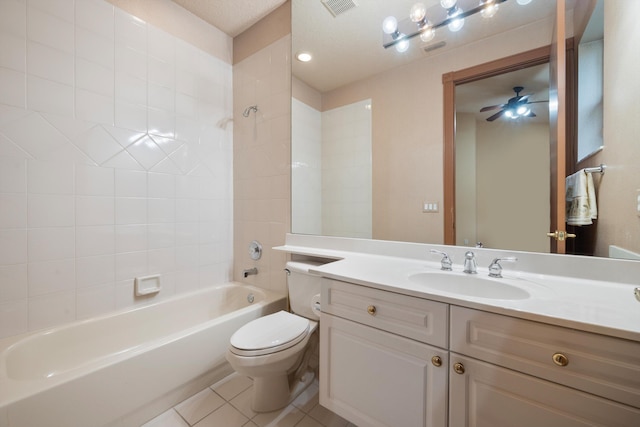 full bathroom featuring vanity, tile patterned floors, tiled shower / bath, toilet, and a textured ceiling