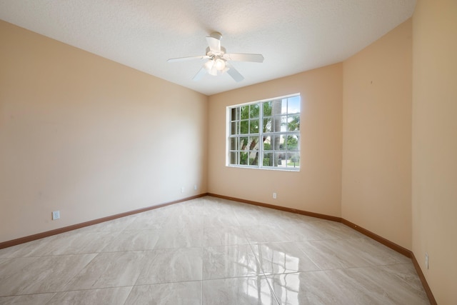 empty room featuring ceiling fan and a textured ceiling