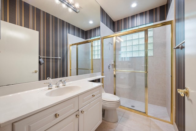 bathroom featuring tile patterned flooring, vanity, toilet, and walk in shower