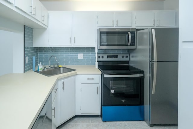 kitchen with backsplash, sink, white cabinets, and appliances with stainless steel finishes