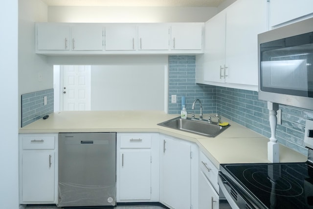 kitchen with sink, backsplash, white cabinets, and appliances with stainless steel finishes