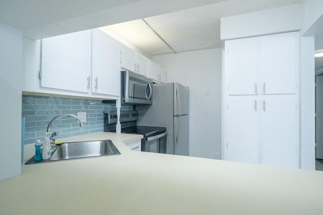 kitchen featuring sink, tasteful backsplash, white cabinetry, and stainless steel appliances