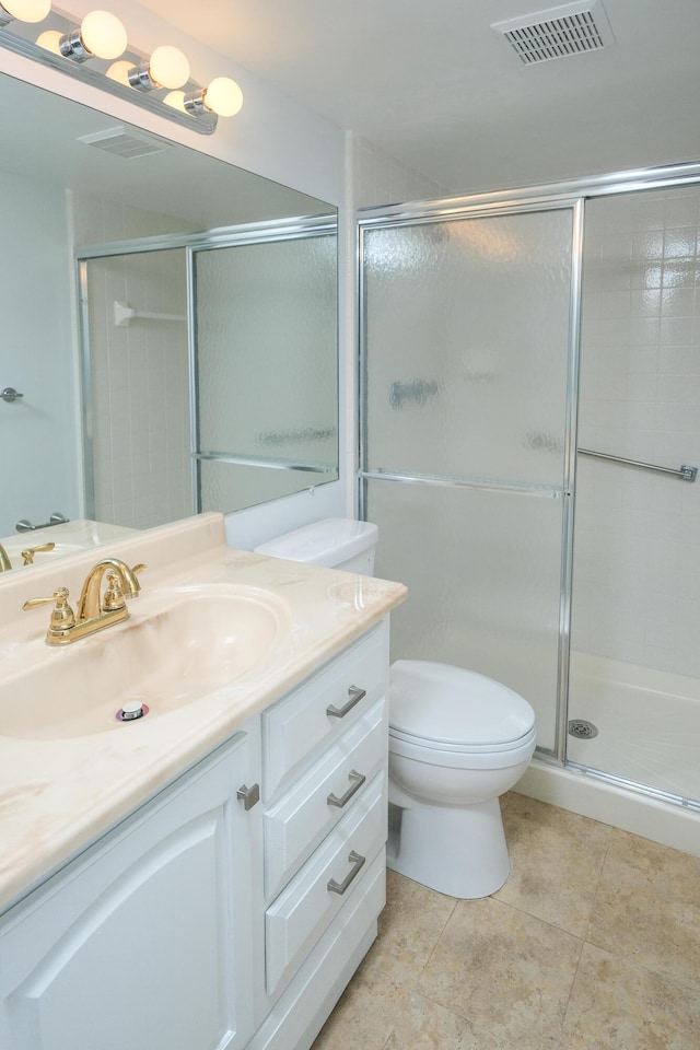 bathroom featuring vanity, toilet, and a shower with door