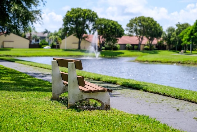 view of community featuring a water view and a yard