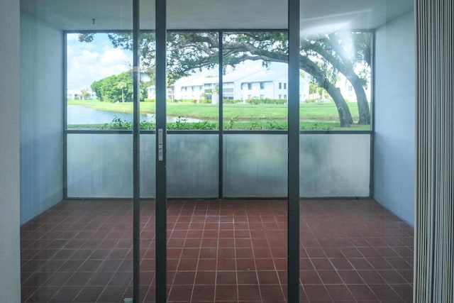 unfurnished sunroom featuring a water view