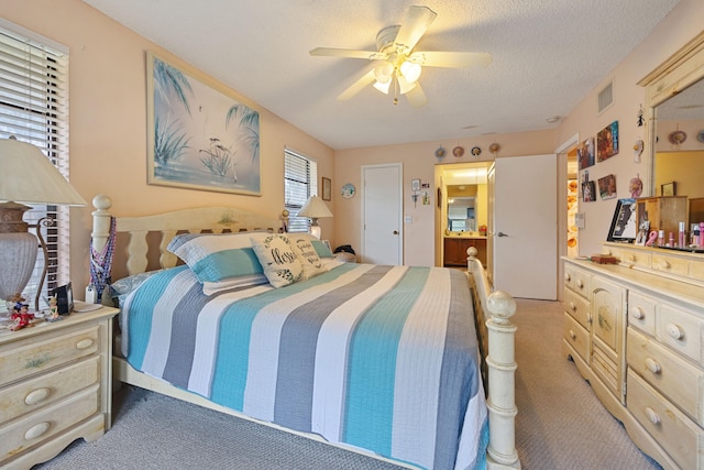 bedroom featuring a ceiling fan, carpet, visible vents, and a textured ceiling