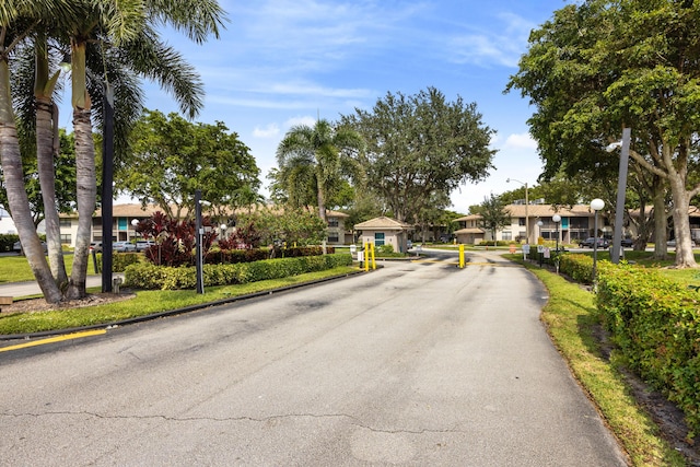 9780 Pineapple Tree Dr Unit 201, Boynton Beach, FL 33436 - view of asphalt road featuring street lights, a gated entry, a residential view, and curbs