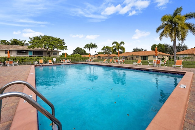 community pool featuring fence and a patio