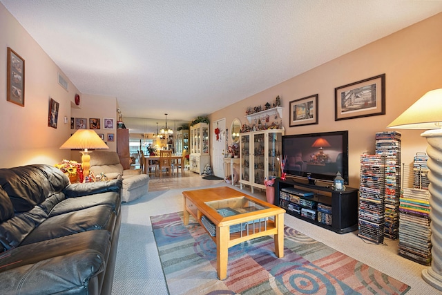 carpeted living room with an inviting chandelier, visible vents, and a textured ceiling