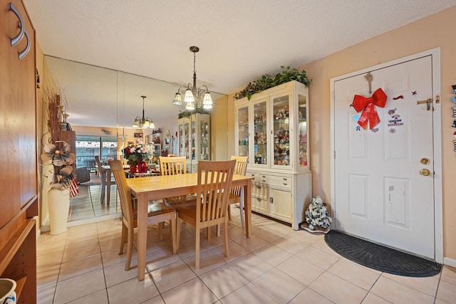 dining room featuring a chandelier, light tile patterned floors, and a textured ceiling