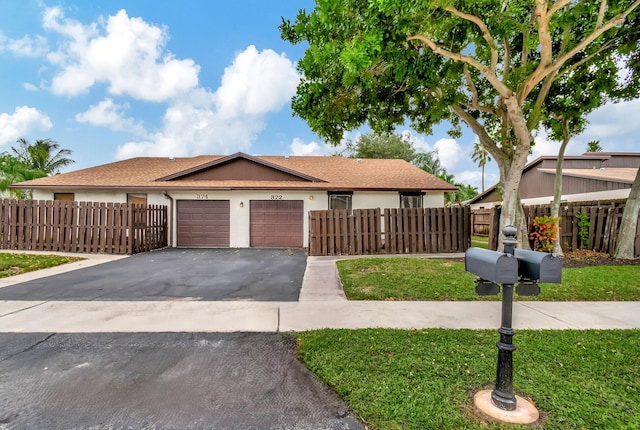 ranch-style house featuring a front yard and a garage