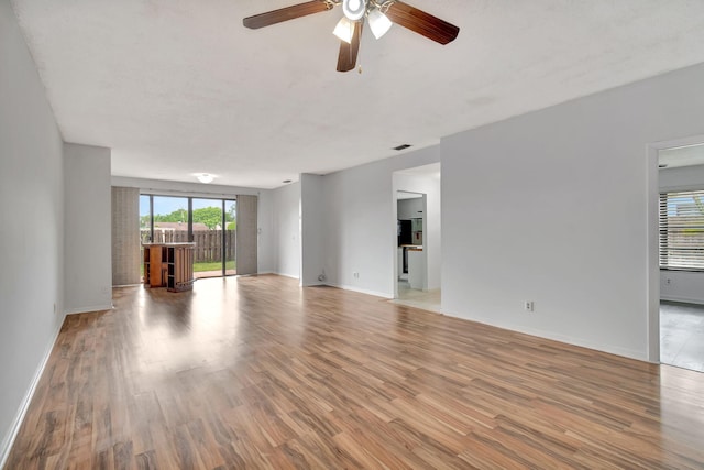 unfurnished living room featuring ceiling fan, a textured ceiling, and light hardwood / wood-style flooring