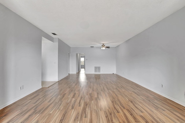 unfurnished living room featuring ceiling fan, a textured ceiling, and hardwood / wood-style floors