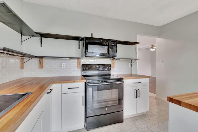 kitchen with black appliances, butcher block counters, ceiling fan, white cabinets, and decorative backsplash