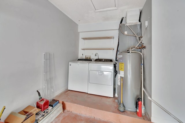 clothes washing area featuring water heater, a textured ceiling, and washing machine and clothes dryer