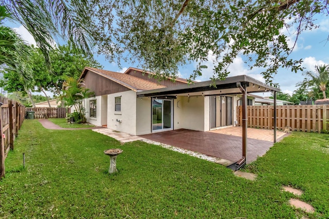 back of property with a patio area and a lawn