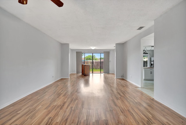 empty room with hardwood / wood-style floors, a textured ceiling, and ceiling fan