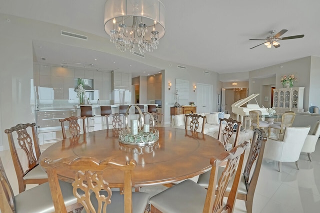 tiled dining area featuring ceiling fan with notable chandelier