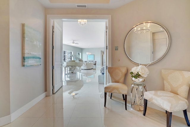 corridor featuring a notable chandelier and light tile patterned floors