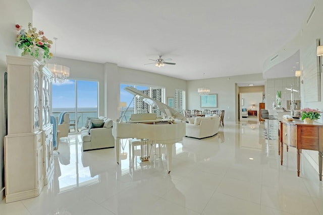 living room with light tile patterned floors, ceiling fan with notable chandelier, and a water view