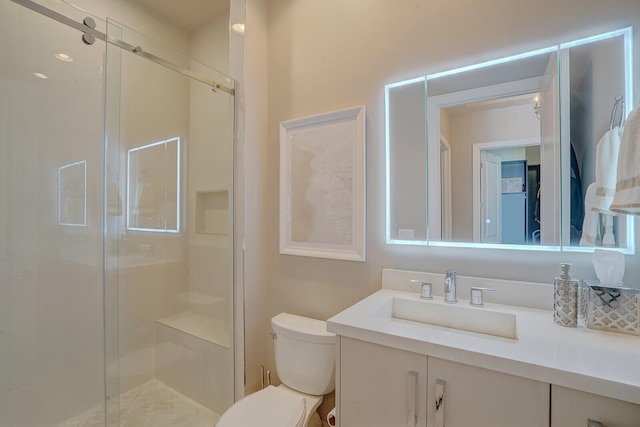 bathroom featuring vanity, a shower with shower door, and toilet