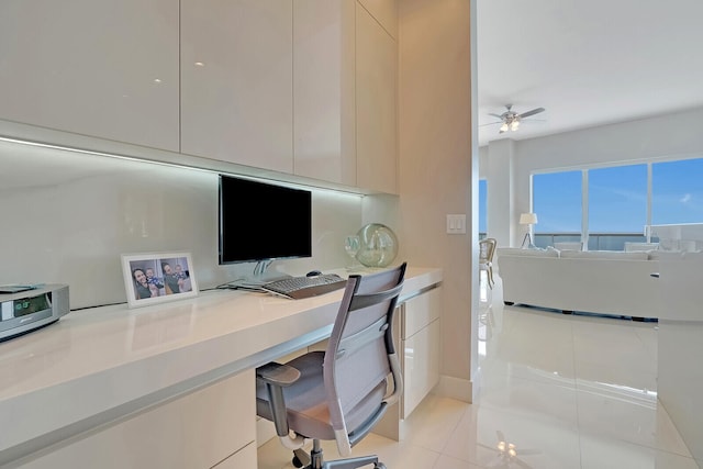 tiled home office featuring ceiling fan