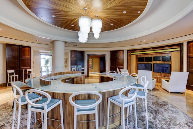 kitchen featuring a notable chandelier, a raised ceiling, and wooden ceiling